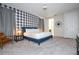 Cozy bedroom offers a soft carpet, buffalo check accent wall, and stylish nautical decor at 9038 Sunshine Ridge Loop, Kissimmee, FL 34747