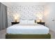 Bright main bedroom with a king bed, decorative wallpaper, and two nightstands with decorative lamps at 9038 Sunshine Ridge Loop, Kissimmee, FL 34747