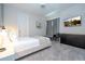 Modern bedroom with light gray carpet, white door, black dresser, bench, chair, and mounted TV at 9038 Sunshine Ridge Loop, Kissimmee, FL 34747