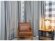 Comfortable bedroom showcasing a reading chair, side table with lamp and gray curtain at 9038 Sunshine Ridge Loop, Kissimmee, FL 34747