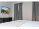 Relaxing bedroom features a flat-screen TV, dark dresser, and gray curtains at 9038 Sunshine Ridge Loop, Kissimmee, FL 34747