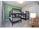 Stylish bedroom featuring two bunk beds, leafy wallpaper, neutral carpet and complementary modern furnishings at 9038 Sunshine Ridge Loop, Kissimmee, FL 34747