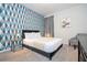 Stylish bedroom featuring a queen bed, geometric wallpaper, and modern decor at 9038 Sunshine Ridge Loop, Kissimmee, FL 34747