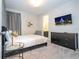 Cozy bedroom with black furniture, modern decor, and a TV, adjacent bathroom at 9038 Sunshine Ridge Loop, Kissimmee, FL 34747
