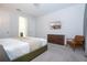 Bright bedroom has a king bed, with a flat-screen television, and chair next to the dresser at 9038 Sunshine Ridge Loop, Kissimmee, FL 34747