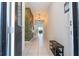 Hallway featuring white tile floors, decorative wall paper, and a view into the open concept living space at 9038 Sunshine Ridge Loop, Kissimmee, FL 34747