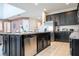 Modern kitchen features stainless steel appliances, granite countertops, island with seating and stylish, dark cabinets at 9038 Sunshine Ridge Loop, Kissimmee, FL 34747