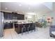 Modern kitchen featuring dark cabinets, stainless steel appliances, and a granite countertop island at 9038 Sunshine Ridge Loop, Kissimmee, FL 34747