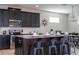 Modern kitchen with dark cabinets, stainless steel appliances, and a spacious island with seating at 9038 Sunshine Ridge Loop, Kissimmee, FL 34747