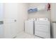 Functional laundry room with washer, dryer, and shelving for storage with white tile flooring at 9038 Sunshine Ridge Loop, Kissimmee, FL 34747