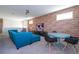 Upstairs living room features a large blue couch, table with chairs, mounted TV and brick accent wall at 9038 Sunshine Ridge Loop, Kissimmee, FL 34747