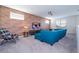 Upstairs living room features a large blue couch, a mounted TV, brick accent wall, and plenty of natural light at 9038 Sunshine Ridge Loop, Kissimmee, FL 34747