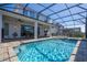 Sparkling blue pool and hot tub in a screened-in enclosure, with ample patio space for lounging and entertaining outdoors at 9038 Sunshine Ridge Loop, Kissimmee, FL 34747
