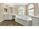 Bathroom features a large soaking tub, arched windows, and updated vanity area at 922 Hatteras Ave, Minneola, FL 34715