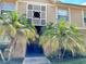 Inviting entryway with palm trees, decorative lattice, and covered access to the building at 9926 Turf Way # 8, Orlando, FL 32837