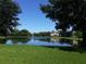 A picturesque pond with fountain surrounded by lush greenery and community buildings in the background at 9926 Turf Way # 8, Orlando, FL 32837