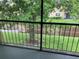 A peaceful screened porch featuring a green space with trees and a waterway beyond the railing at 9926 Turf Way # 8, Orlando, FL 32837