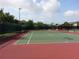 Well-maintained tennis court with red and green surface, perfect for recreational play within the community at 9926 Turf Way # 8, Orlando, FL 32837