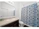 Clean bathroom featuring a vanity sink, toilet, and tiled shower with a stylish patterned curtain at 997 La Mirada Ct, Kissimmee, FL 34744