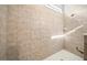 Large walk-in shower with beige ceramic tile surround, a shower bench and a ceiling height window for natural light at 997 La Mirada Ct, Kissimmee, FL 34744