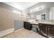Bright bathroom with double sink vanity, granite countertops, custom cabinets, and walk-in shower with beige tile surround at 997 La Mirada Ct, Kissimmee, FL 34744