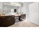 Bathroom featuring a double vanity with dark brown cabinetry, granite countertops and a large framed mirror and tiled floors at 997 La Mirada Ct, Kissimmee, FL 34744