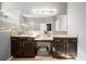Bathroom featuring a double vanity with dark brown cabinetry, granite countertops and a large framed mirror and tiled floors at 997 La Mirada Ct, Kissimmee, FL 34744