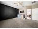 Cozy bedroom showcases a decorative accent wall, plush carpet, ceiling fan, and a view into the Primary bathroom at 997 La Mirada Ct, Kissimmee, FL 34744