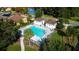 Aerial view of community pool, surrounded by lush trees, pool furniture, and several cabana-style structures at 997 La Mirada Ct, Kissimmee, FL 34744