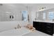 Bathroom featuring a soaking tub with brass fixtures, a dark wood vanity and frameless glass shower at 1071 Kershaw Dr, Winter Garden, FL 34787