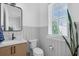 Clean half-bath includes modern fixtures, wood-look cabinets, and a large window with natural light at 1071 Kershaw Dr, Winter Garden, FL 34787