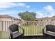 Cozy balcony with two chairs overlooking a serene green lawn and neighboring buildings at 1084 Park Ridge Cir, Kissimmee, FL 34746