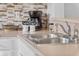 Kitchen with stainless steel sink, tile backsplash and a modern coffee maker on the countertop at 1084 Park Ridge Cir, Kissimmee, FL 34746