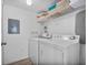 Functional laundry room features a washer, dryer, ironing board, and storage at 1084 Park Ridge Cir, Kissimmee, FL 34746
