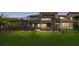 Large backyard with spa, patio seating, and grassy lawn enclosed by a black metal fence at 13125 Alderley Dr, Orlando, FL 32832