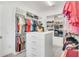 Walk-in closet with rows of organized shelves, hanging racks, and a central storage unit at 13125 Alderley Dr, Orlando, FL 32832