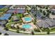 Aerial view of community clubhouse, tennis courts, parking, and swimming pool with splash pad at 13125 Alderley Dr, Orlando, FL 32832