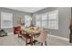 Bright dining room with a modern table set, light-colored walls, and ample natural light from large windows at 13125 Alderley Dr, Orlando, FL 32832