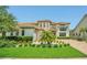 Beautiful two-story home with lush landscaping and a well-manicured lawn at 13125 Alderley Dr, Orlando, FL 32832