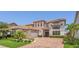 Beautiful two-story home with a well-manicured lawn, mature landscaping, and a brick paver driveway at 13125 Alderley Dr, Orlando, FL 32832