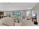 Open-concept living room with neutral tones, a large sectional sofa, and access to the outdoor patio at 13125 Alderley Dr, Orlando, FL 32832