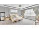 Bright main bedroom featuring a cushioned bench, cozy chair, and modern nightstands at 13125 Alderley Dr, Orlando, FL 32832