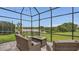 Screened-in patio with comfortable seating around a fire pit table and lake views at 13125 Alderley Dr, Orlando, FL 32832