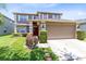 Inviting two-story home with a well-kept lawn, red door, and attached two-car garage at 14883 Hartford Run Dr, Orlando, FL 32828