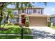 Charming two-story home with a well-manicured lawn and attached two-car garage at 14883 Hartford Run Dr, Orlando, FL 32828