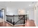 Spacious upstairs hallway featuring wood floors, natural light, and a view of the staircase at 14883 Hartford Run Dr, Orlando, FL 32828