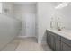 Bright bathroom with a glass-enclosed shower, double vanity, and gray cabinets providing a modern aesthetic at 14925 Lebeau Loop, Winter Garden, FL 34787