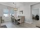Well-lit dining room with a wooden table, upholstered chairs, a bench, and a stylish chandelier at 14925 Lebeau Loop, Winter Garden, FL 34787