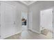 Hallway view with access to an office space and bathroom, featuring neutral paint and tile floors at 14925 Lebeau Loop, Winter Garden, FL 34787