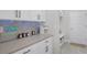 White cabinets with gray backsplash at 14925 Lebeau Loop, Winter Garden, FL 34787